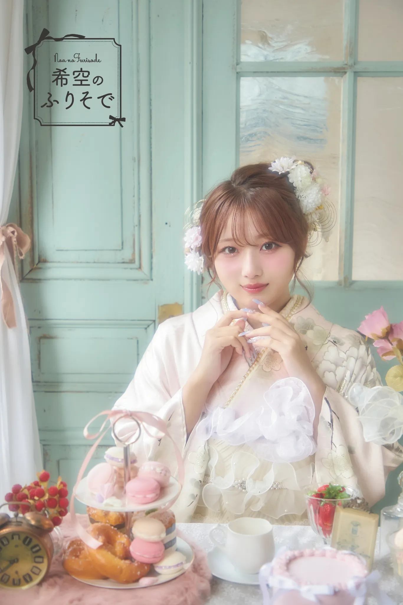 「インフルエンサー希空ちゃんが、淡いピンクのガーリー振袖を着てティータイム風のセットで微笑むシーン。ふんわり透明感のある淡色コーデで、レースやフリルを重ねた可憐な成人式振袖。淡色振袖・ピンク振袖・ガーリー振袖・成人式前撮りを探す方に人気のスタイル。」