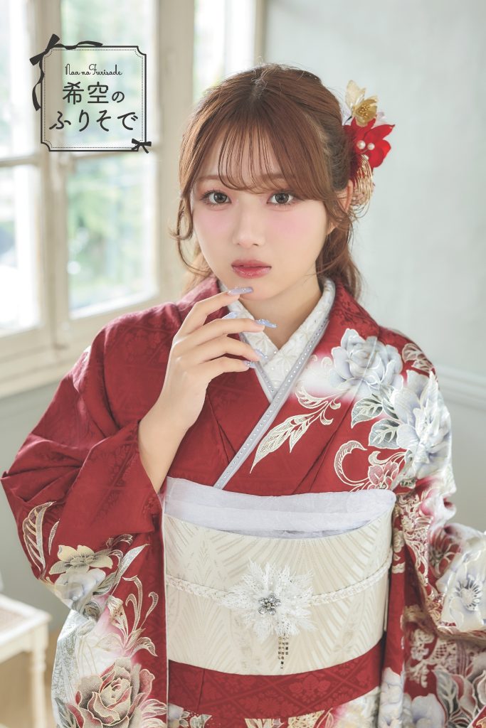 「深紅と白の花柄が華やかな振袖を着た希空(のあ)が、モードで大人っぽいスタイリングで佇む全身写真。」