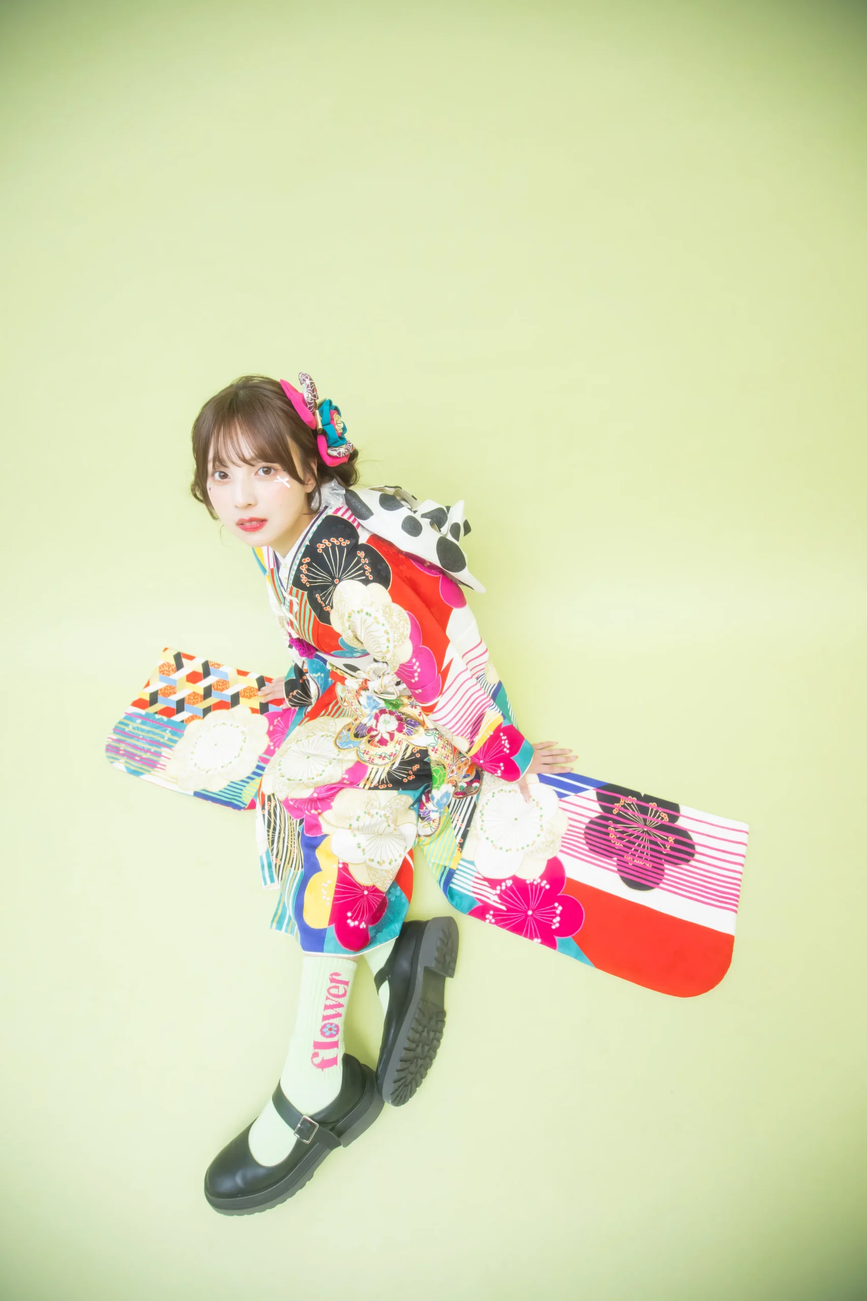 カラフルな古典柄とストライプが印象的なポップ振袖を着用した女性の全身スタジオ写真。成人式振袖レンタルPLUM（プラム）岐阜・一宮対応