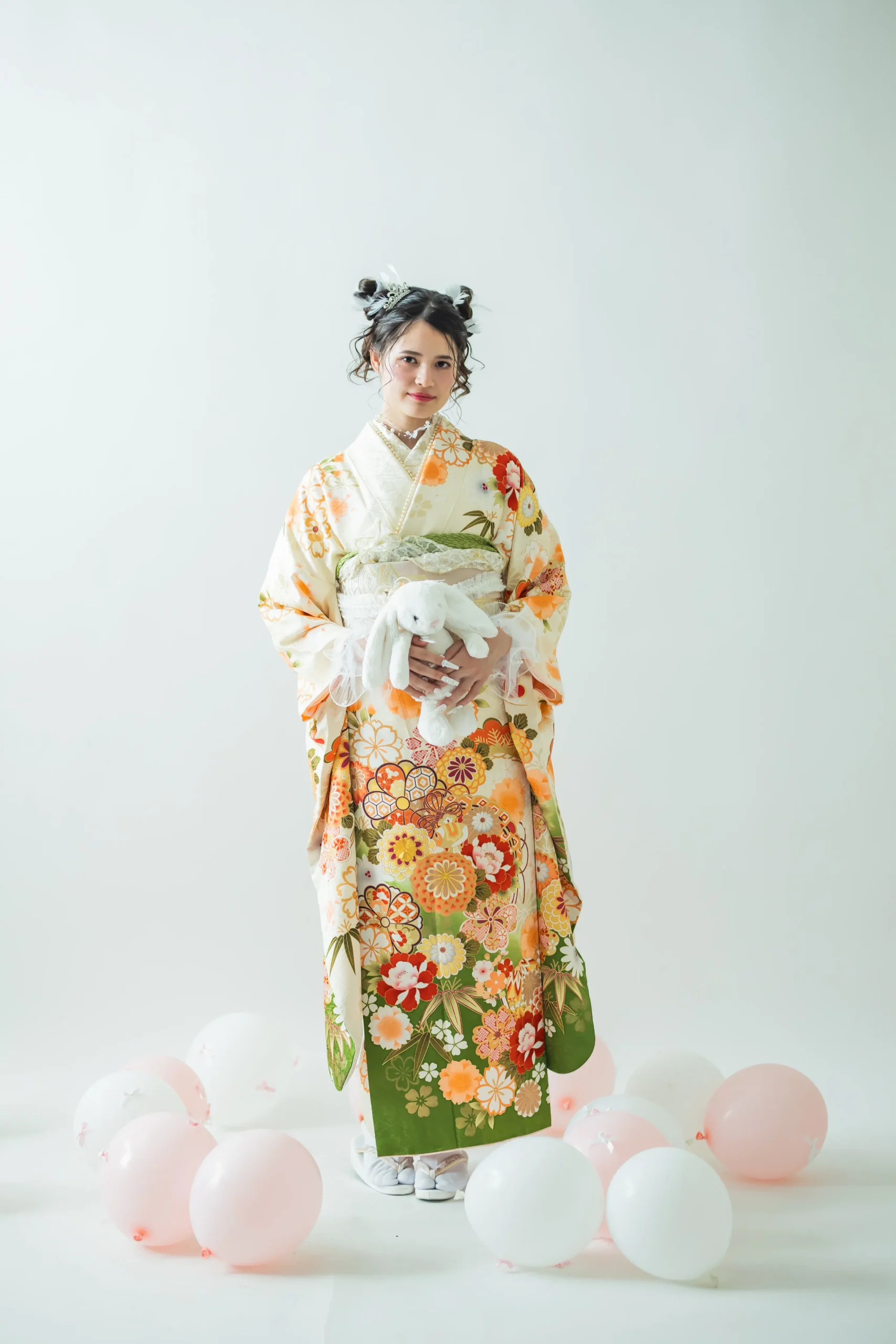 白地にオレンジと緑の古典花柄が華やかな正統派振袖を着用した女性の全身スタジオ写真。成人式振袖レンタルPLUM（プラム）岐阜・一宮対応
