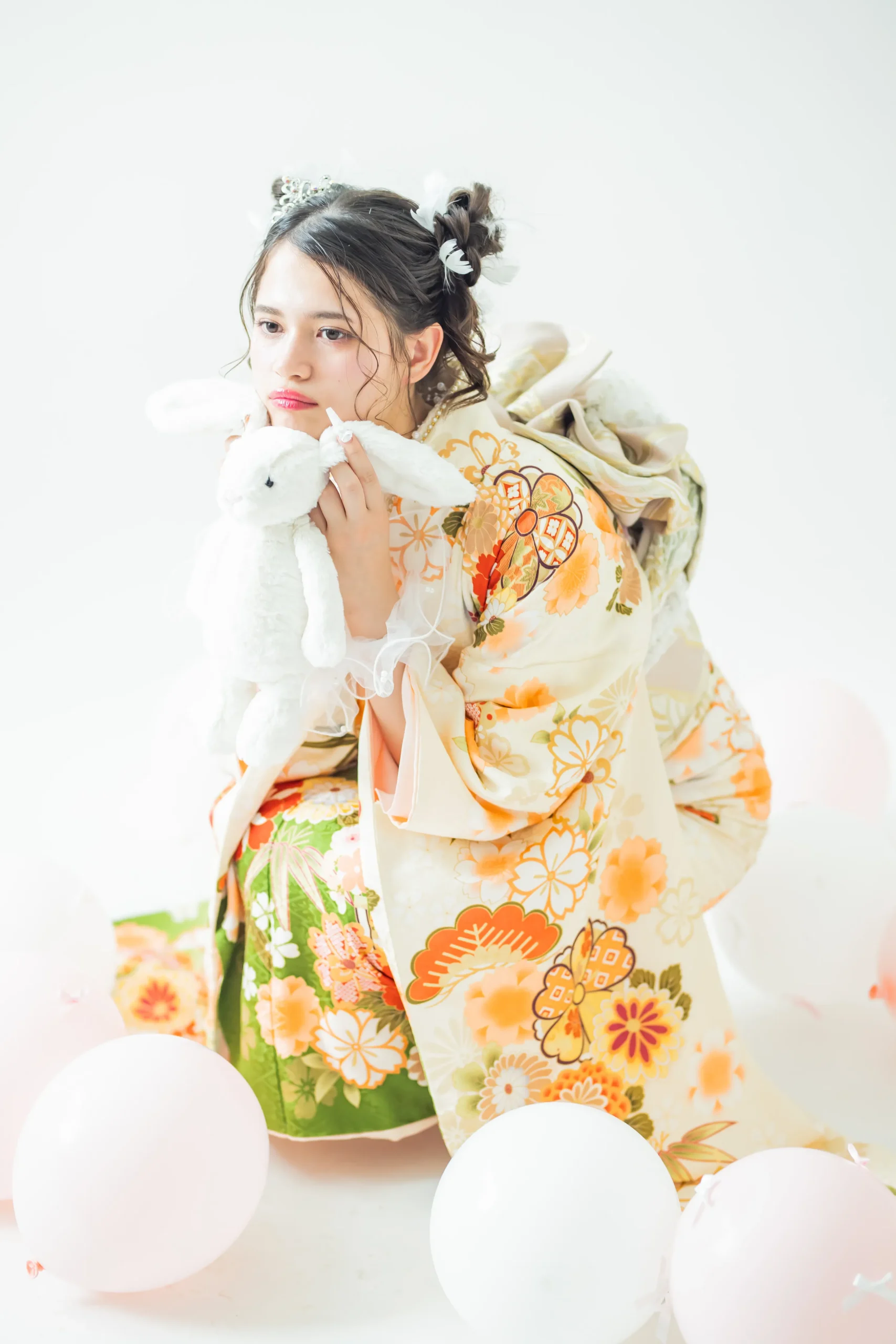 白地にオレンジと緑の古典花柄が華やかな正統派振袖を着用した女性の全身スタジオ写真。成人式振袖レンタルPLUM（プラム）岐阜・一宮対応