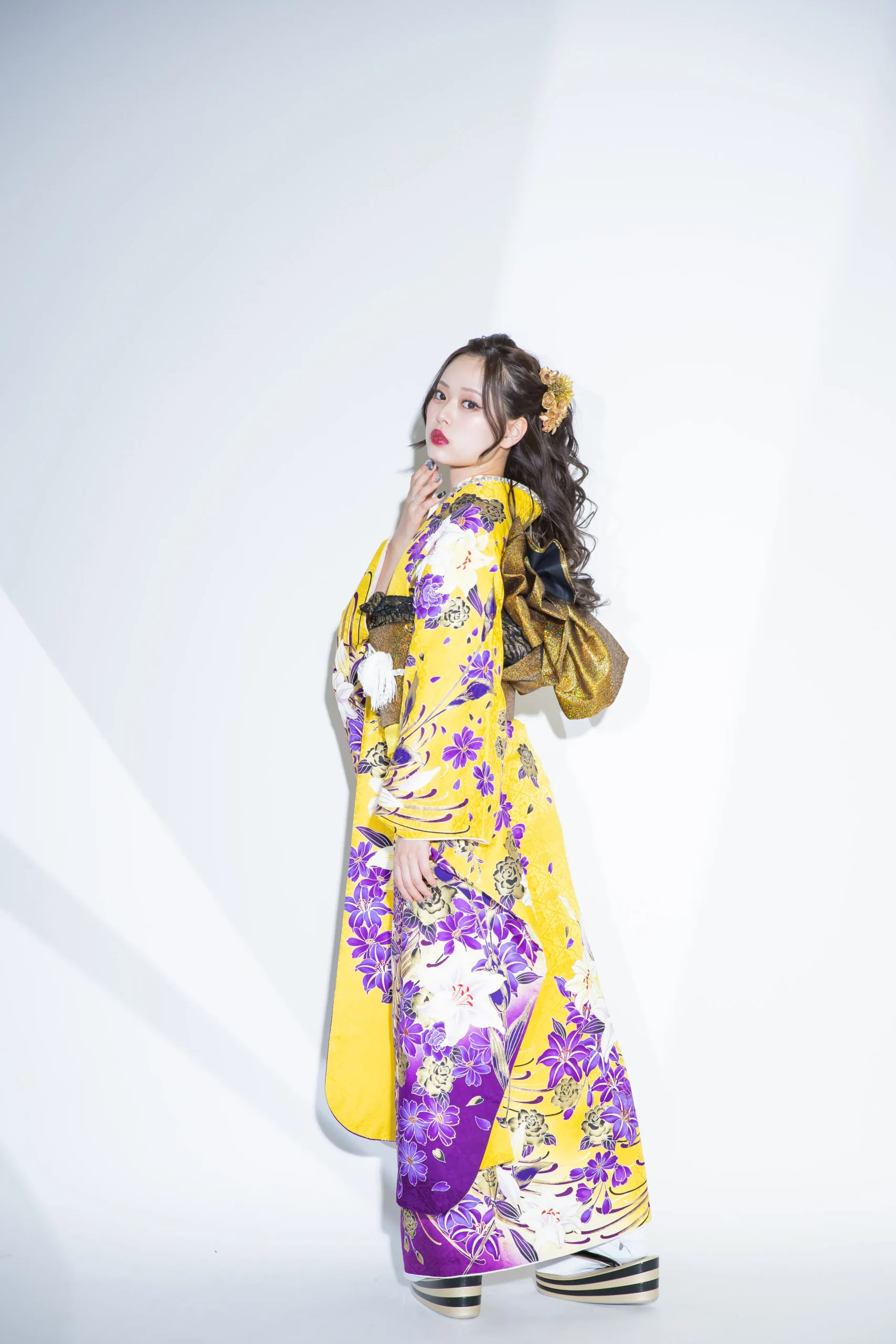 黄色地に紫と白の百合柄が映える華やかな古典振袖を着用した女性の全身スタジオ写真。成人式振袖レンタルPLUM（プラム）岐阜・一宮対応