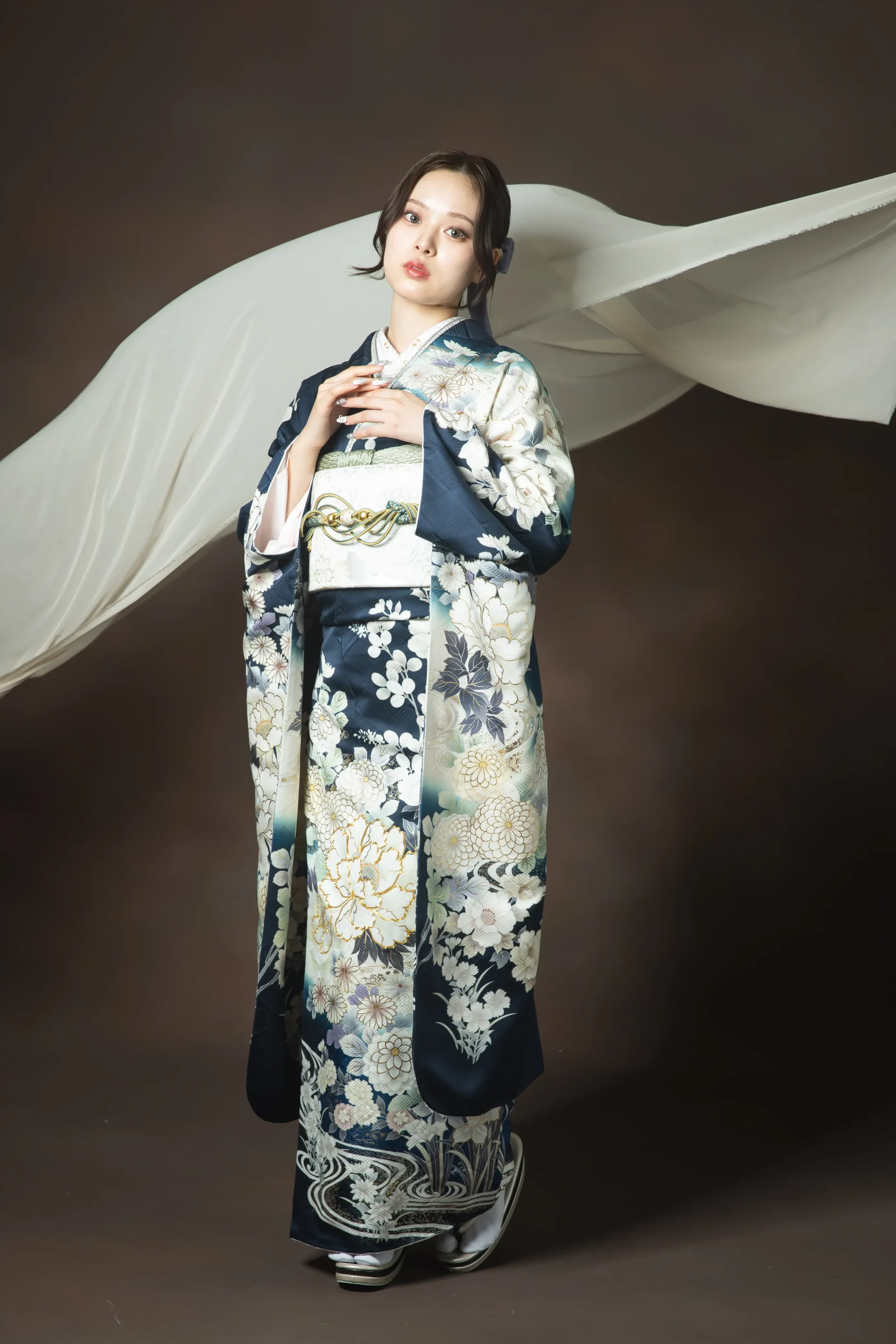 深いネイビー地に白と金の花柄が上品に描かれた大人古典振袖を着用した女性の全身スタジオ写真。成人式振袖レンタルPLUM（プラム）岐阜・一宮対応