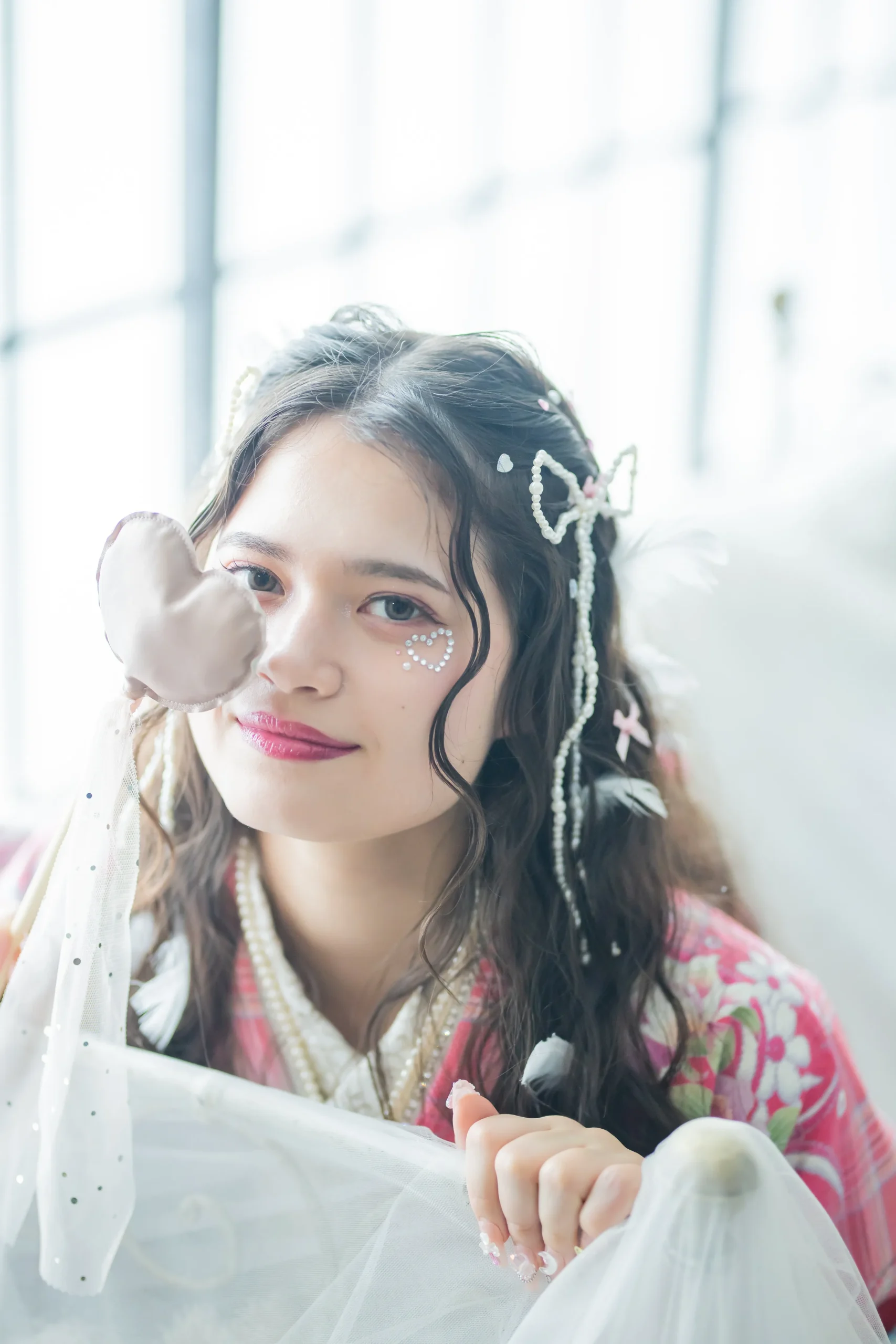 白地にピンクを基調とした花柄とロゴデザインが可愛いガーリー振袖を着用した女性の全身スタジオ写真。成人式振袖レンタルPLUM（プラム）岐阜・一宮対応