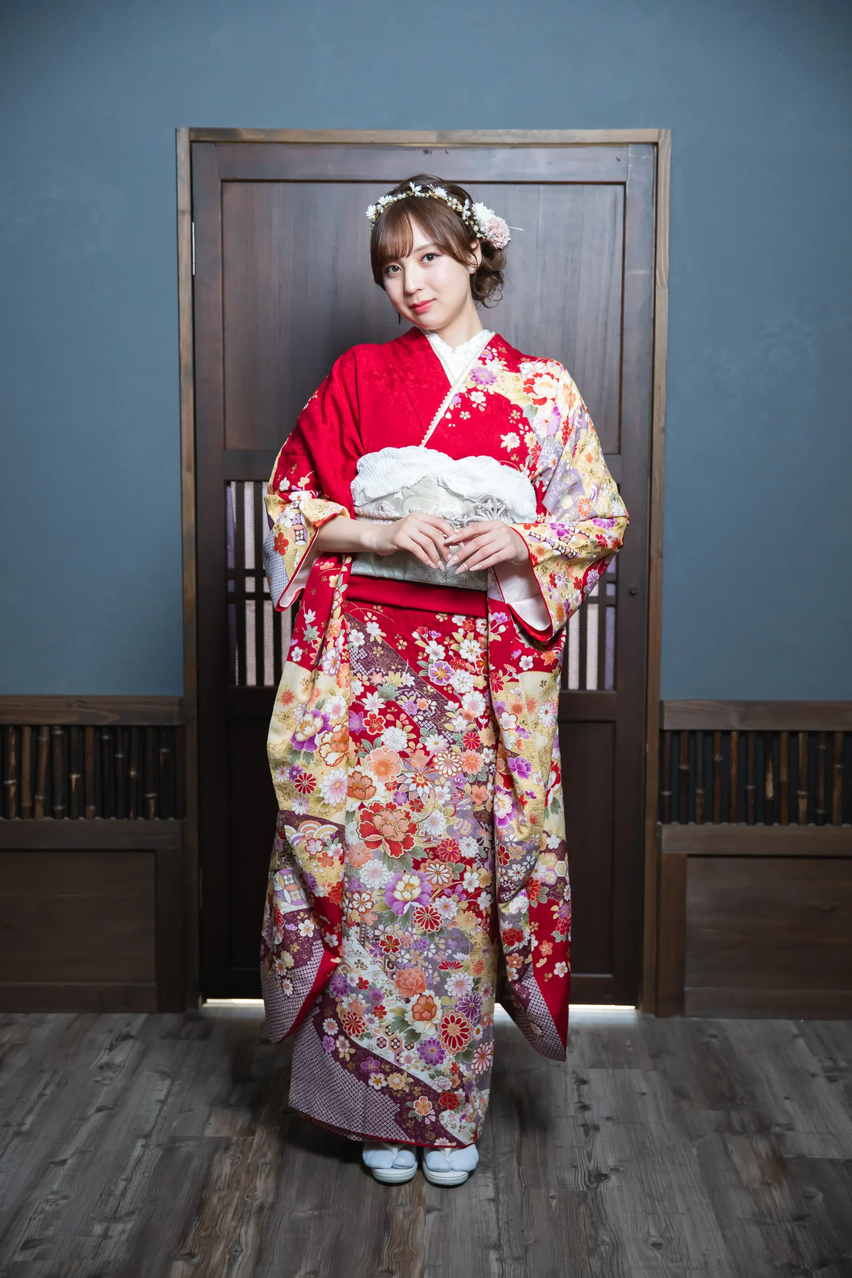 赤地に色とりどりの古典花柄が華やかに描かれた正統派振袖を着用した女性の全身写真。成人式振袖レンタルPLUM（プラム）岐阜・一宮対応