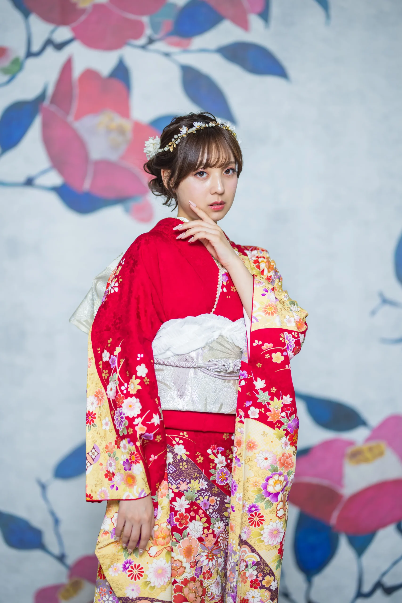 赤地に色とりどりの古典花柄が華やかに描かれた正統派振袖を着用した女性の全身写真。成人式振袖レンタルPLUM（プラム）岐阜・一宮対応