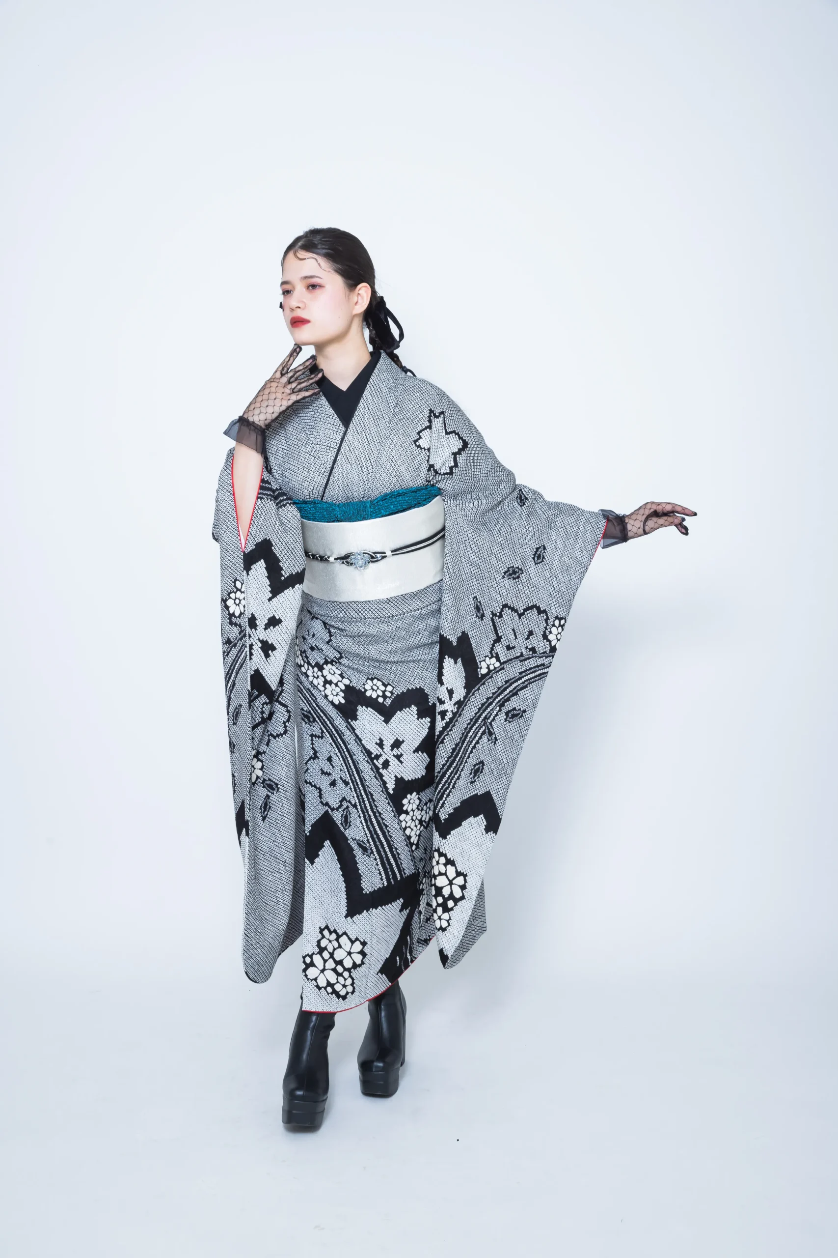 グレー地に黒の幾何学柄と花文様が描かれたモード系振袖を着用した女性の全身スタジオ写真。成人式振袖レンタルPLUM（プラム）岐阜・一宮対応