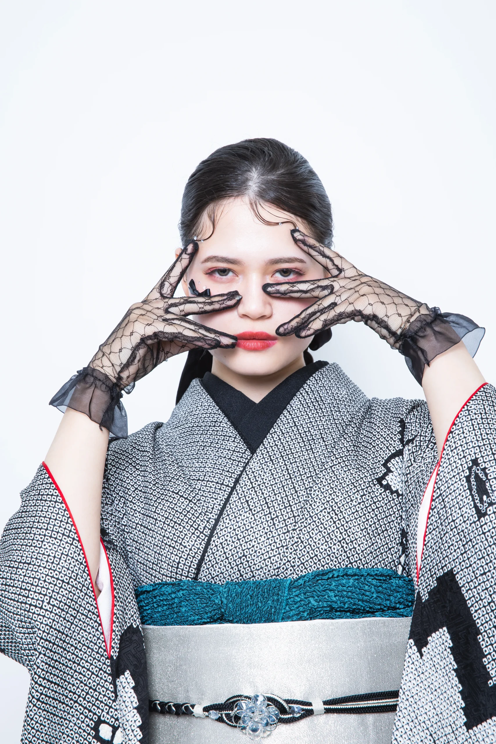 グレー地に黒の幾何学柄と花文様が描かれたモード系振袖を着用した女性の全身スタジオ写真。成人式振袖レンタルPLUM（プラム）岐阜・一宮対応