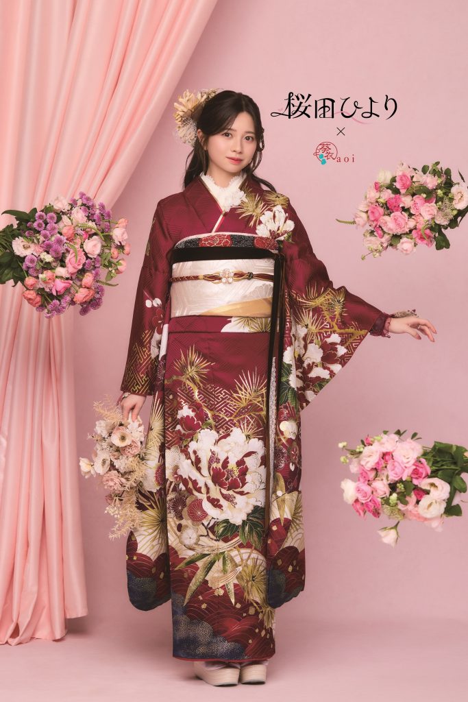 桜田ひより着用の赤系振袖。深みのあるワインレッド地に牡丹や松文様が豪華に描かれた、成人式向けの華やかで上品な振袖コーディネート。