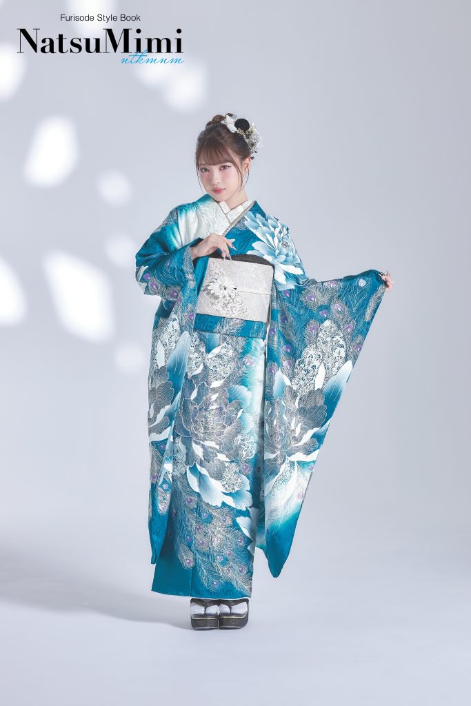インフルエンサーみなみちゃん着用のブルーグリーン振袖。白を基調にした大胆な花柄と透明感のある青が印象的な、成人式・前撮り向けの華やかで上品な振袖スタイル。
