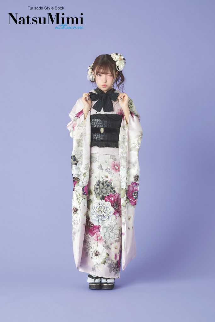 インフルエンサーみなみちゃん着用の淡いピンク振袖。大輪の花柄と黒の帯を合わせた甘すぎないデザインで、成人式や前撮りに映える上品で大人可愛い振袖スタイル。
