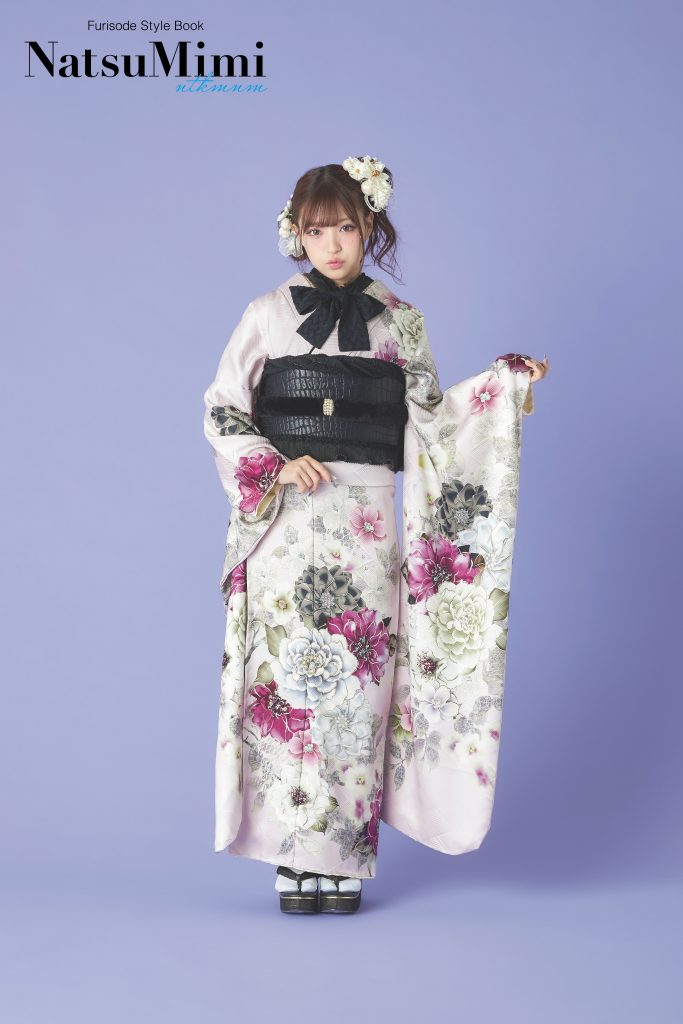 インフルエンサーみなみちゃん着用の淡いピンク振袖。大輪の花柄と黒の帯を合わせた甘すぎないデザインで、成人式や前撮りに映える上品で大人可愛い振袖スタイル。