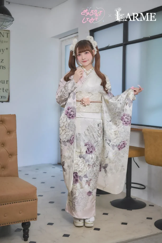 きゅるりんってしてみて×LARMEコラボの新作振袖。アイボリー地にくすみパープルの花柄が描かれた上品で可愛い振袖を着た女性の成人式前撮りスタイル。岐阜・愛知の振袖専門店PLUMで取り扱い。