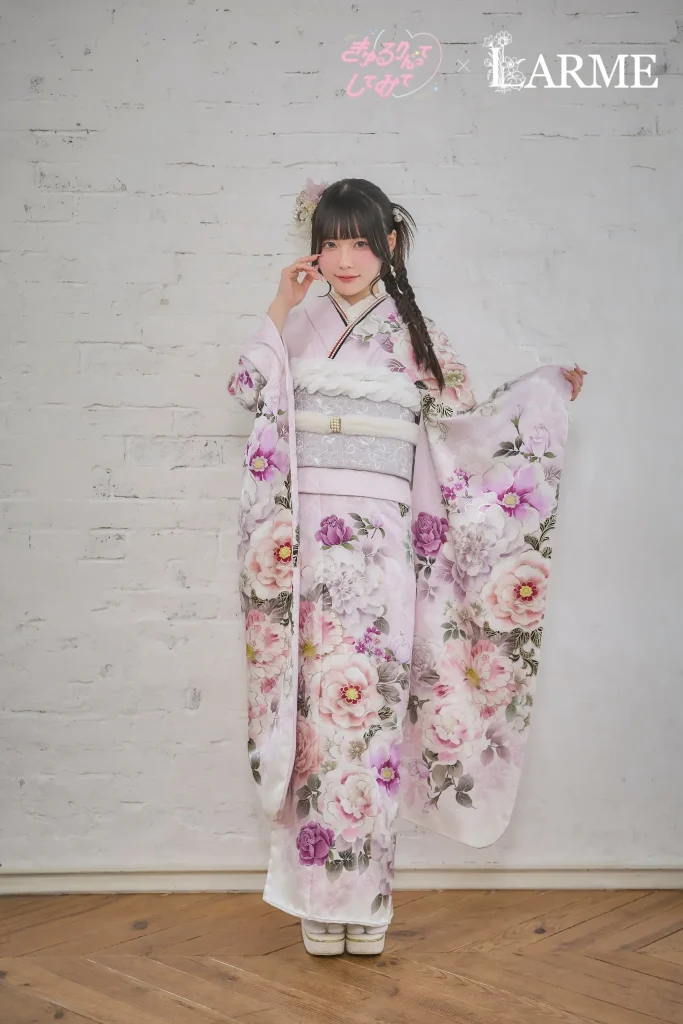 きゅるりんってしてみて×LARMEコラボの新作振袖。淡いラベンダーピンク地に大きな花柄が描かれた、可憐で透明感のある振袖を着た女性の成人式前撮りスタイル。岐阜・愛知の振袖専門店PLUMで取り扱い。